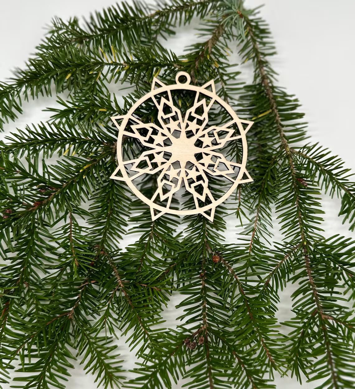 Decorative snowflake ornament on a branch with a white background