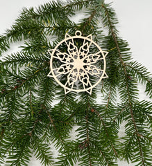 Decorative snowflake ornament on a branch with a white background