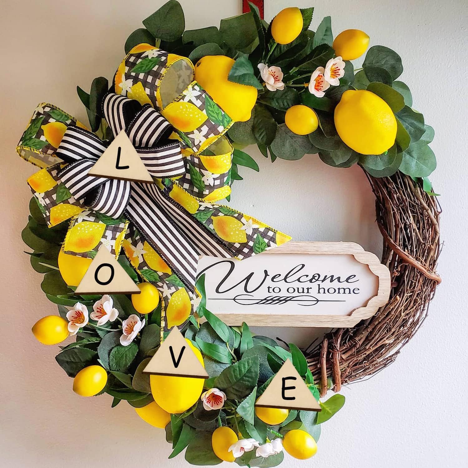 Decorative wreath with lemons, greenery, and a 'Welcome to our home' sign.