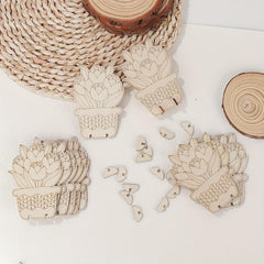 Wooden succulent plant cutouts on a white surface with natural wood elements.