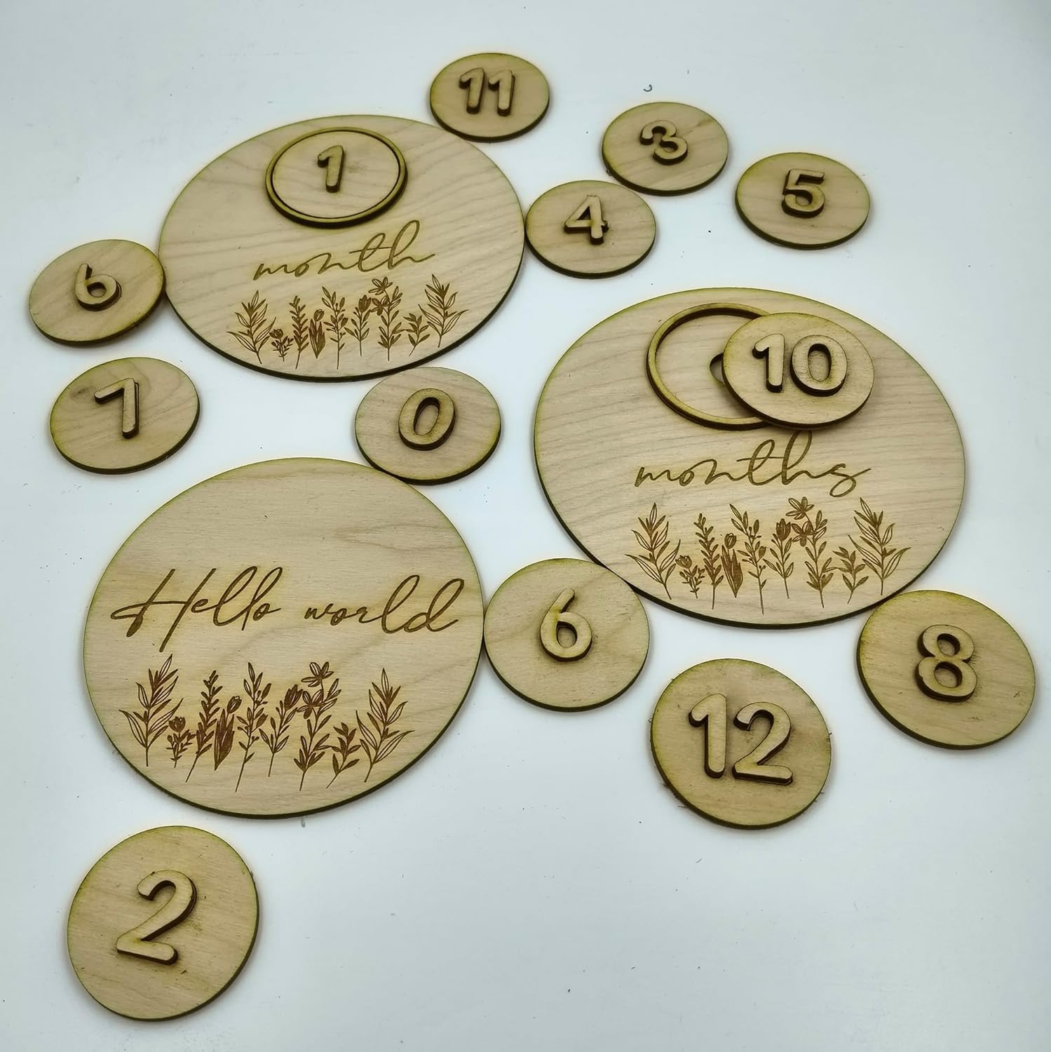 Wooden milestone discs with numbers and 'Hello world' text on a white background
