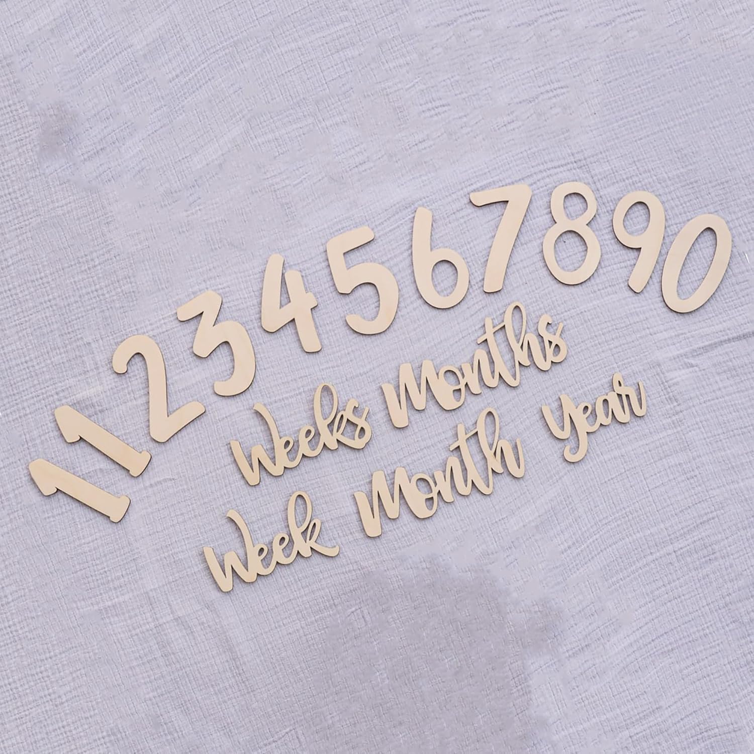 Wooden numbers and text pieces on a textured light gray background