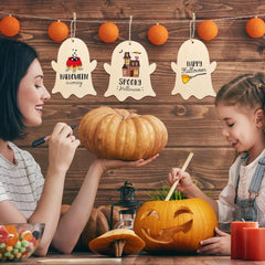 Two women carving pumpkins with Halloween-themed decorations on a wooden wall.