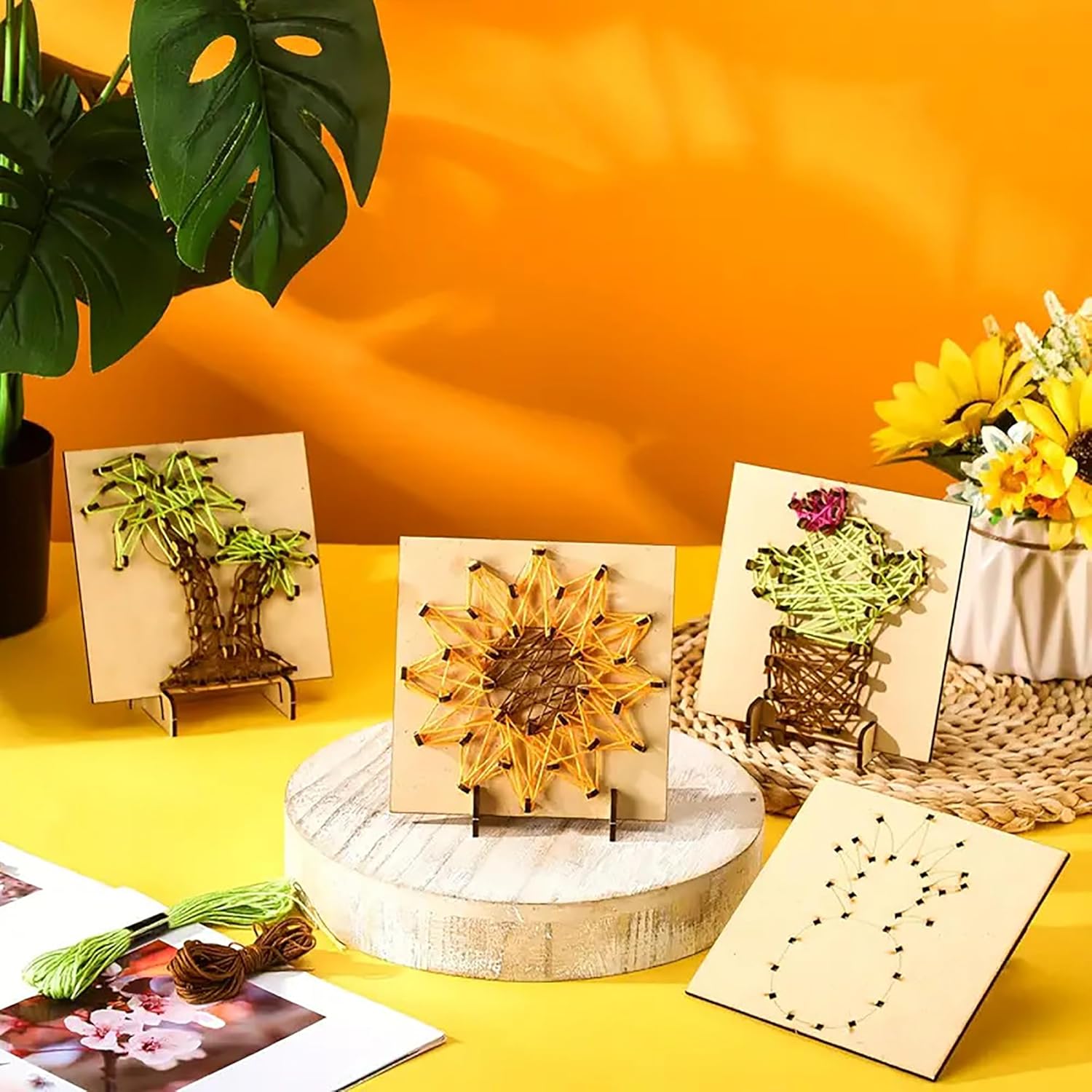 Decorative items on a yellow surface with a plant in the corner