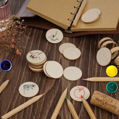 Wooden coasters with drawings, markers, and a notebook on a wooden surface