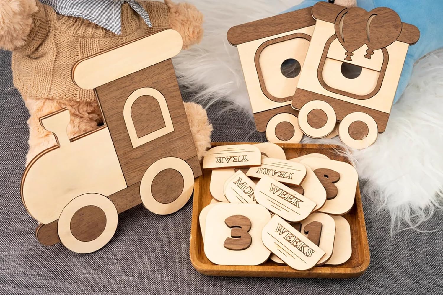 Wooden toy train with age milestone cards on a textured surface