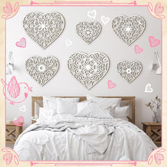 Decorative heart-shaped wall art above a bed in a bedroom setting.
