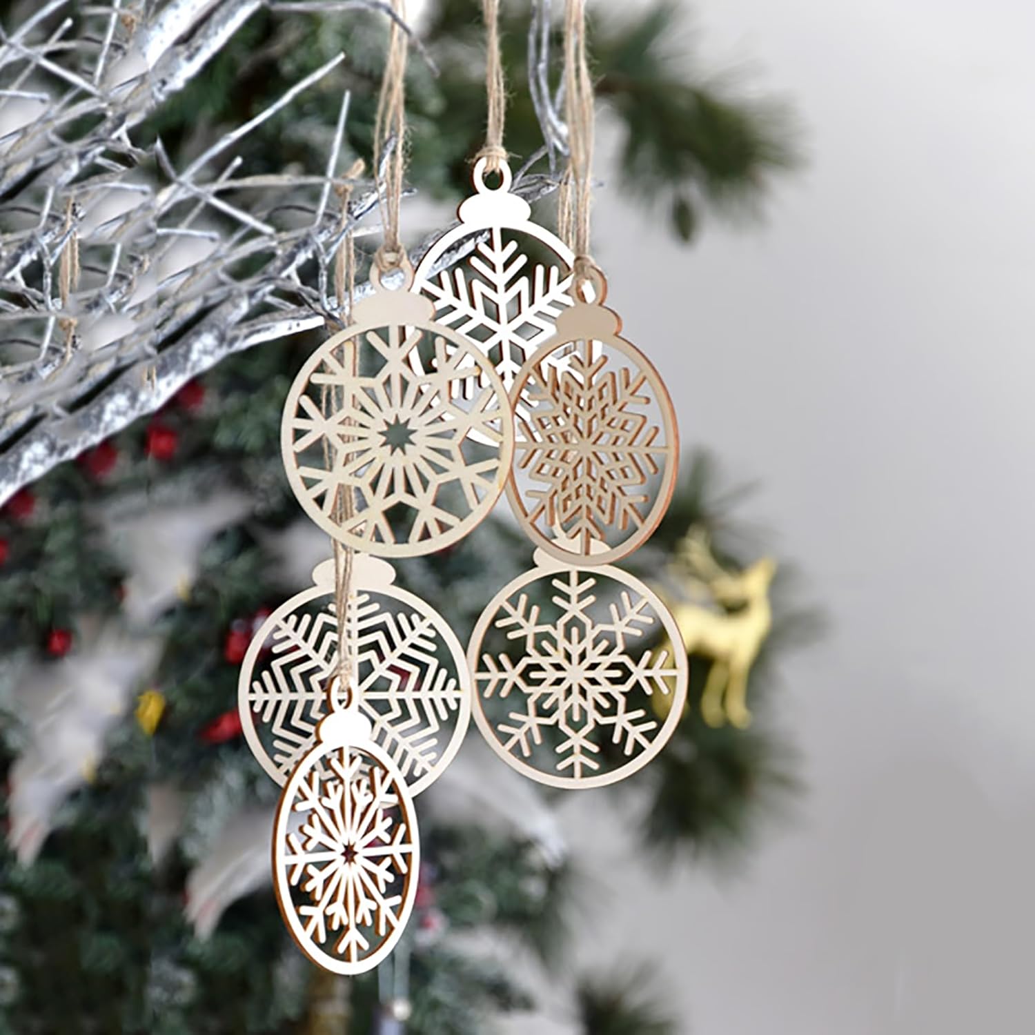 Decorative snowflake ornaments hanging on a Christmas tree.