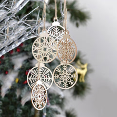 Decorative snowflake ornaments hanging on a Christmas tree.