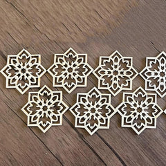 Set of laser-cut snowflake shapes on a wooden surface