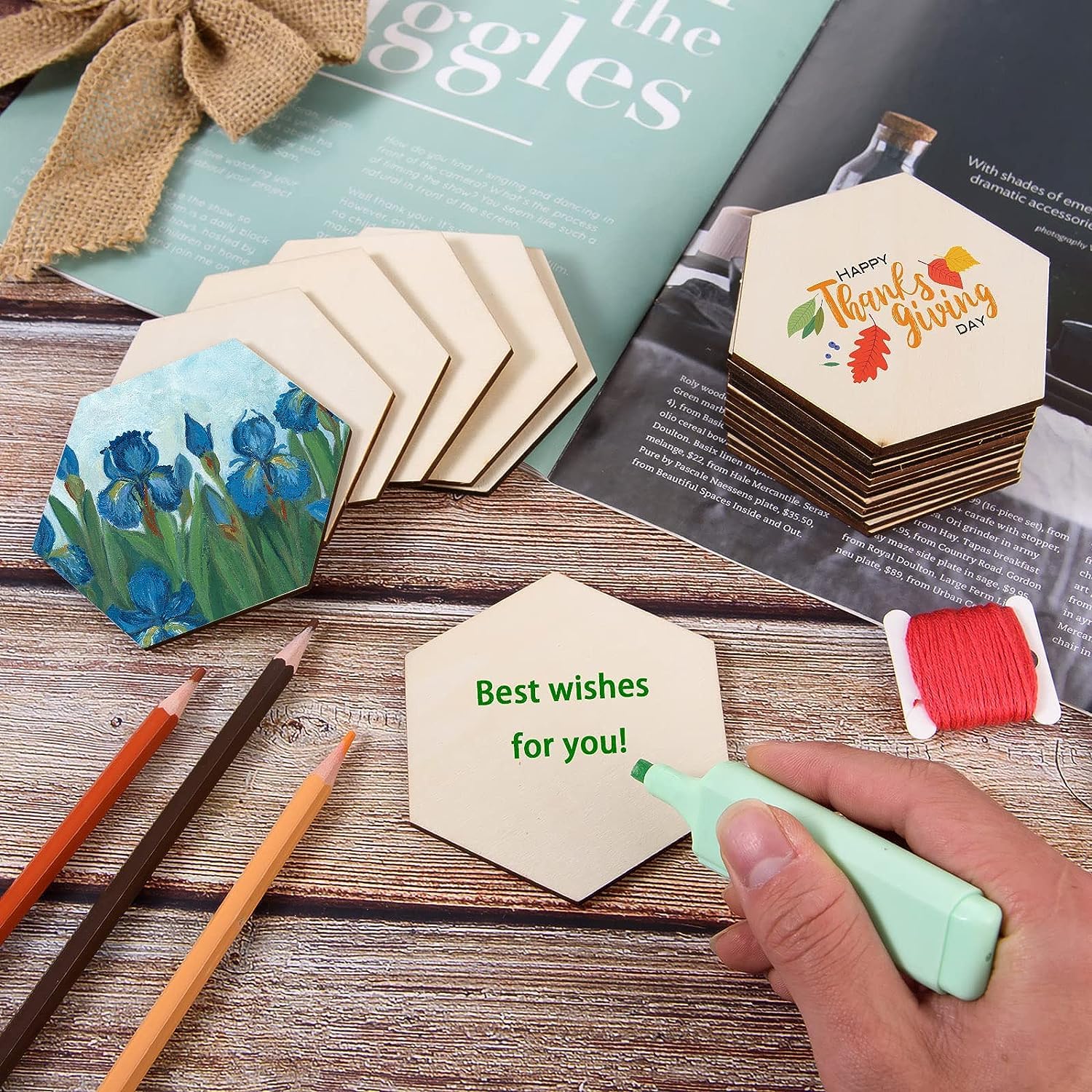 Hexagonal coasters with artistic designs and text, on a wooden surface with markers and pencils.