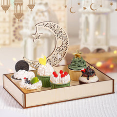 Decorative tray with small cakes and a moon and star ornament on a blurred festive background.