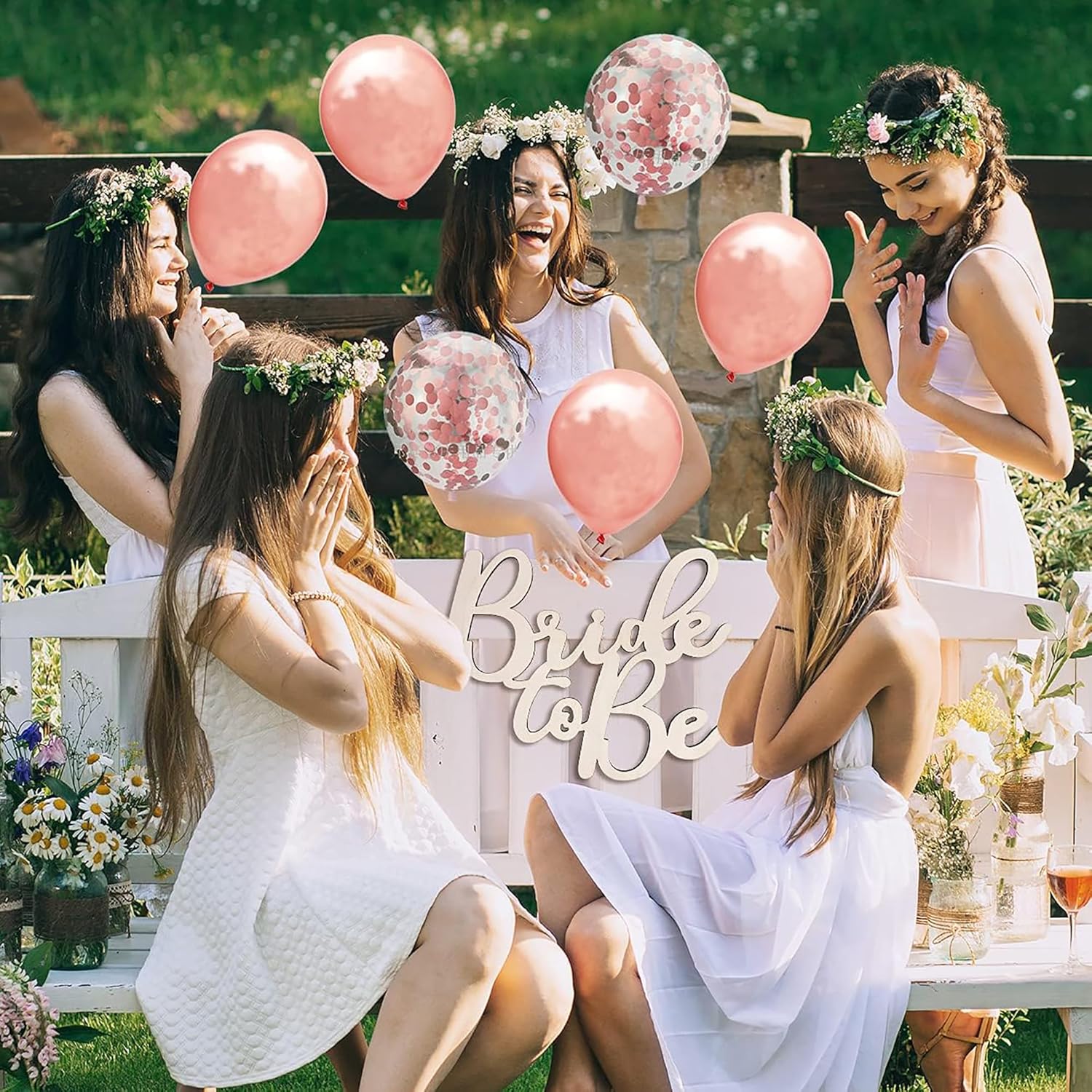 Group of women celebrating a bridal shower with pink balloons and 'Bride to Be' sign.