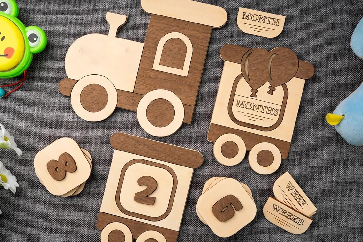 Wooden baby milestone cards with train design on a textured surface