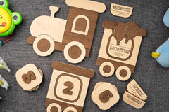 Wooden baby milestone cards with train design on a textured surface