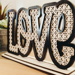 Decorative wooden letters spelling 'LOVE' on a wooden base.