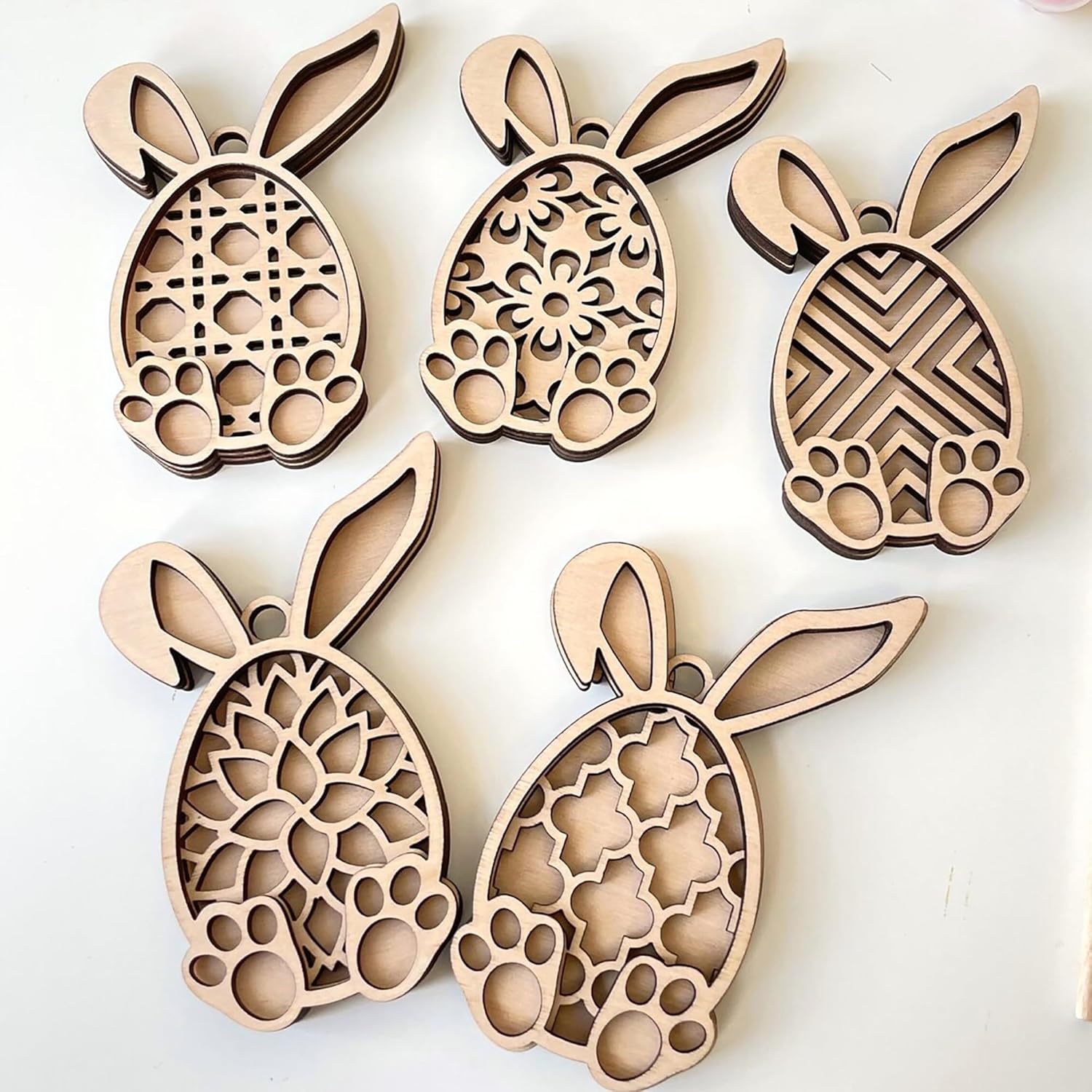 Wooden bunny-shaped cutouts with intricate patterns on a white background