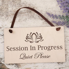 Decorative sign with a lotus flower symbol and text on a wooden background