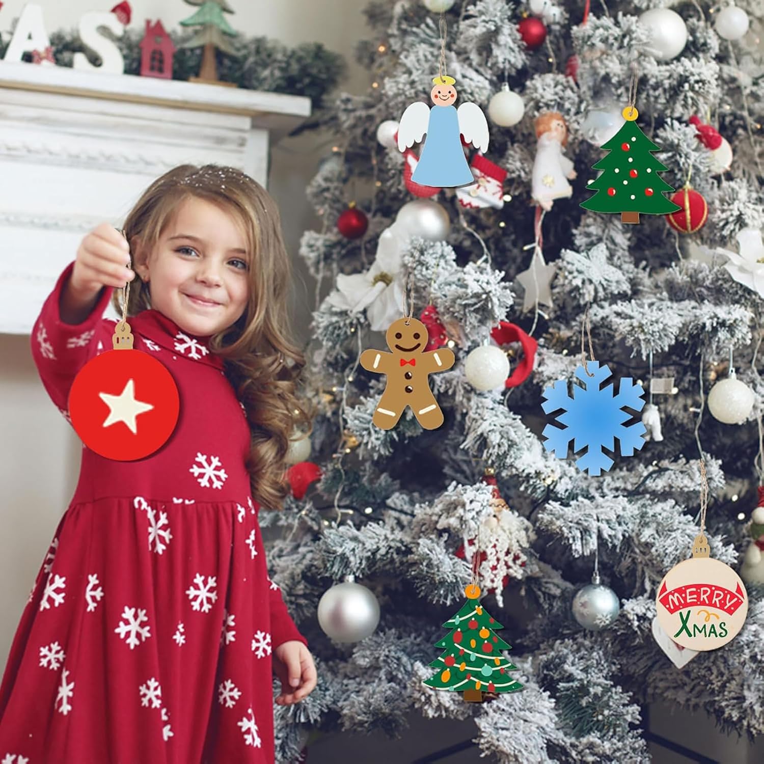 Child in a red dress with snowflake pattern standing next to a Christmas tree decorated with various ornaments.