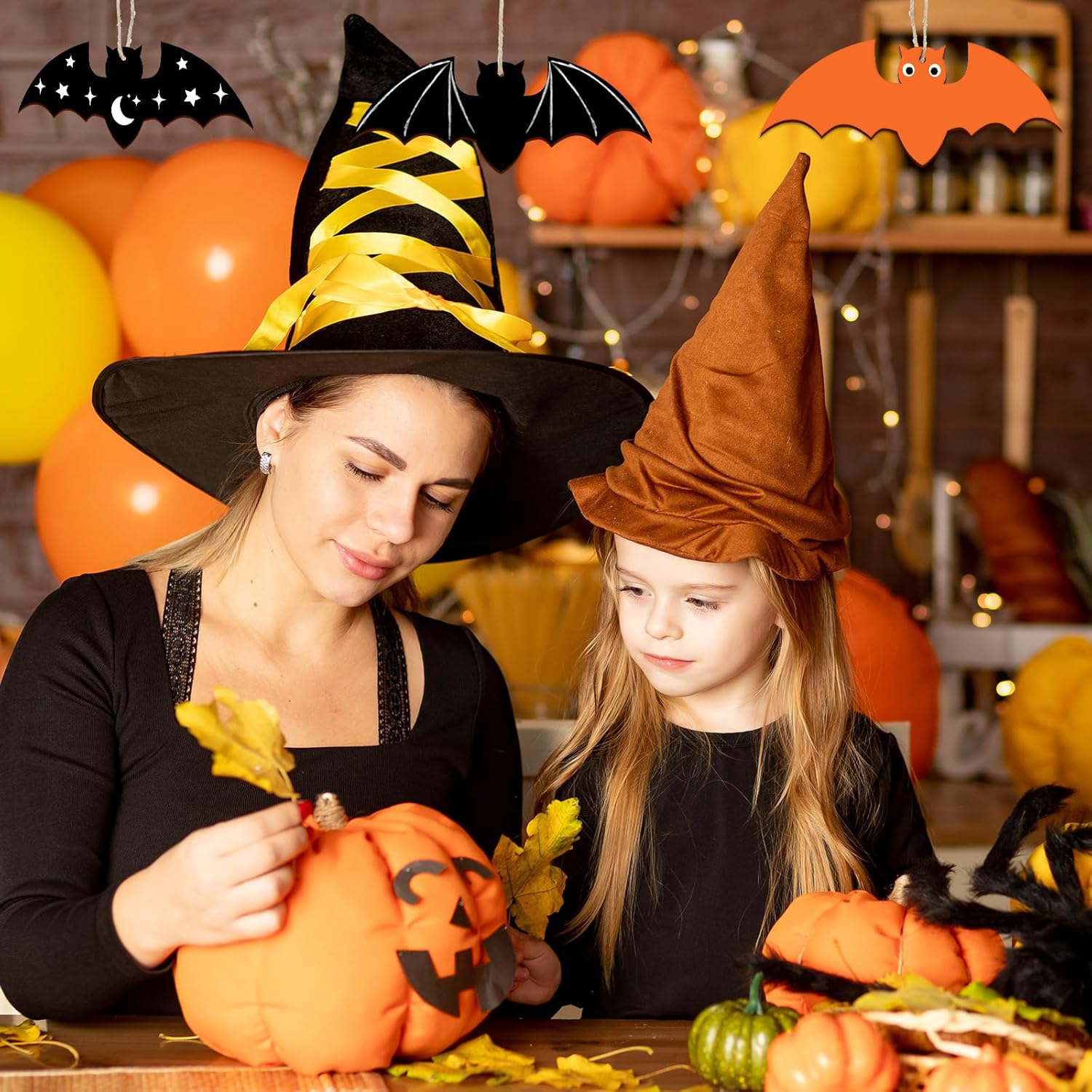 Woman and child in Halloween costumes carving pumpkins together.