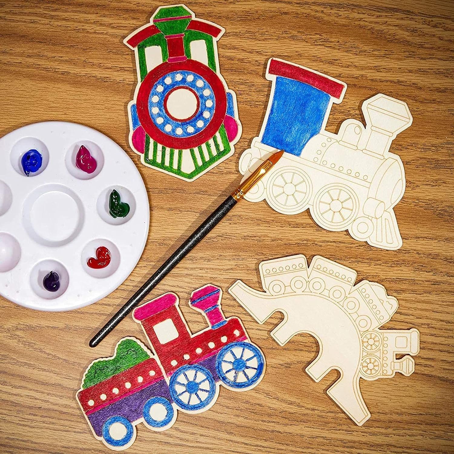 Colorful train-shaped wooden toys with a paint palette and brush on a wooden surface