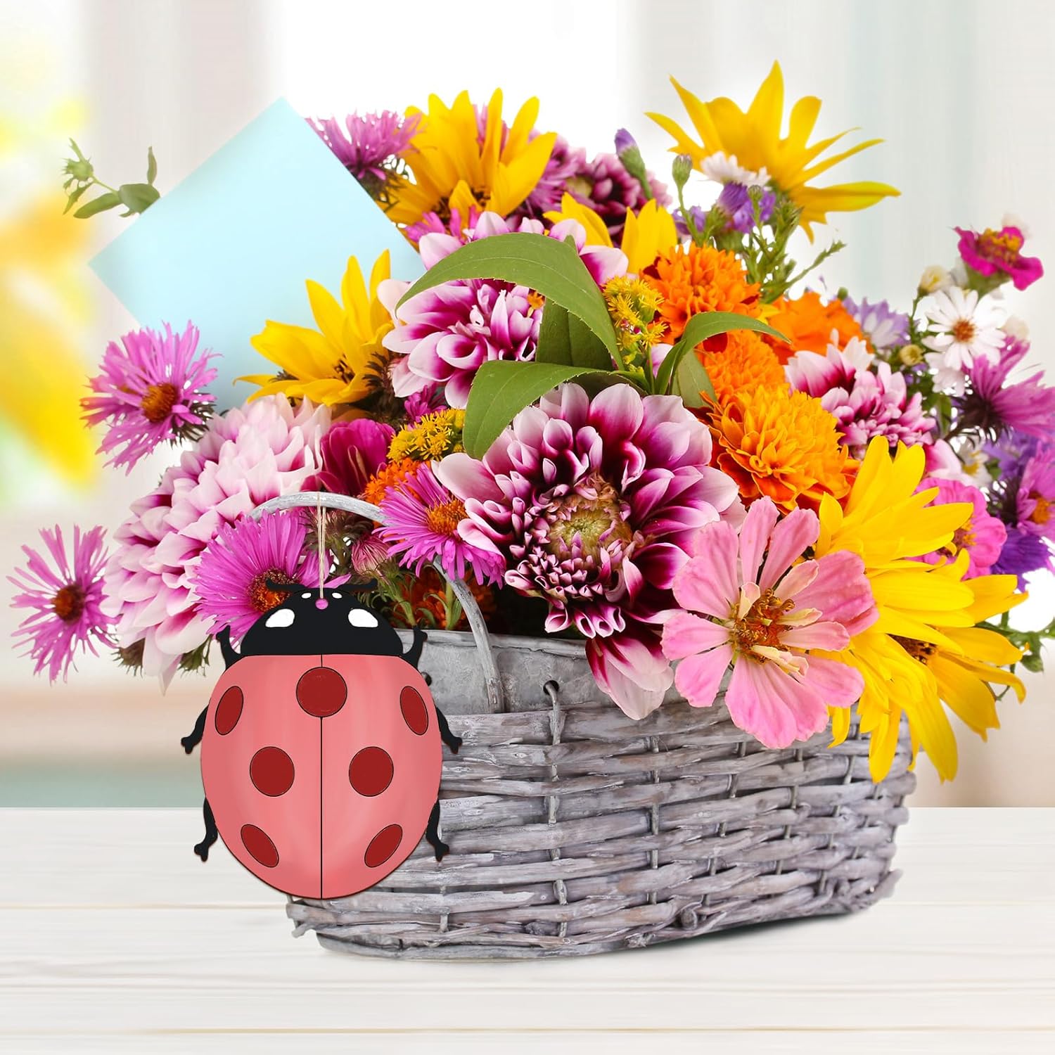 Colorful bouquet of flowers in a basket with a ladybug design on a light background