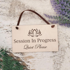 Wooden sign with 'Session In Progress Quiet Please' text and lotus flower symbol on a rustic wooden background.