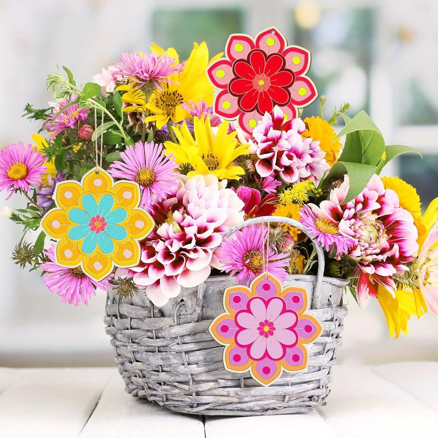 Bouquet of colorful flowers in a woven basket with decorative flower-shaped tags.
