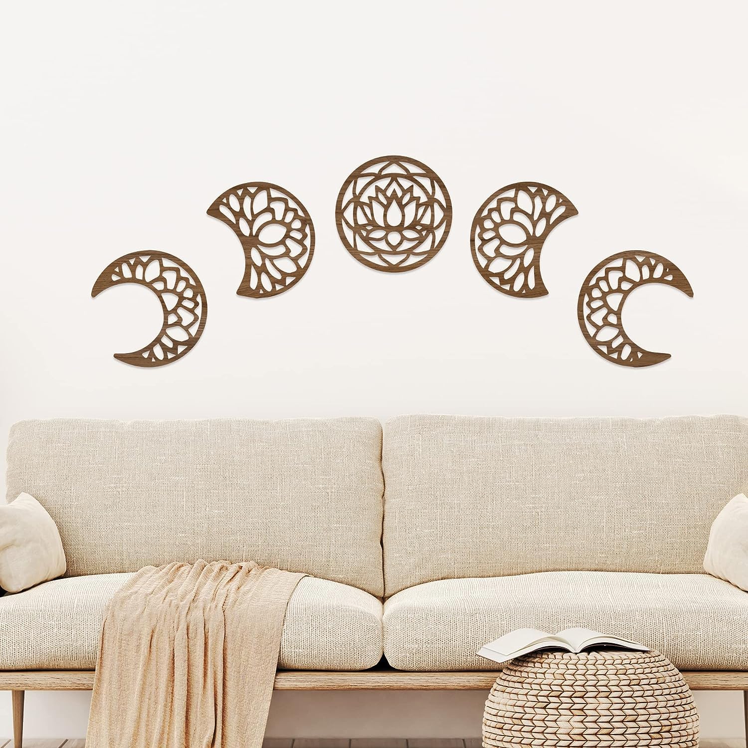 Decorative wall stickers of celestial designs on a white wall above a beige sofa.