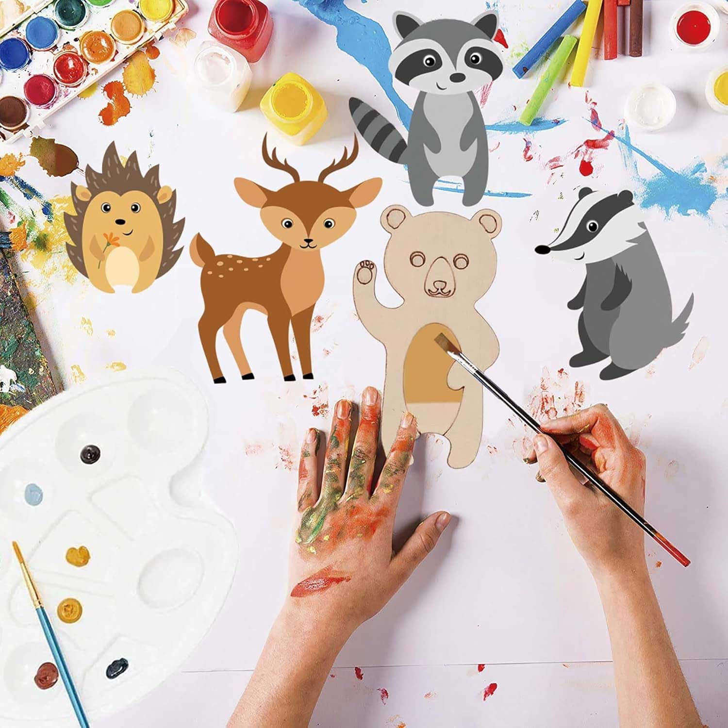 Children's art project with animal cutouts and painting supplies on a white background