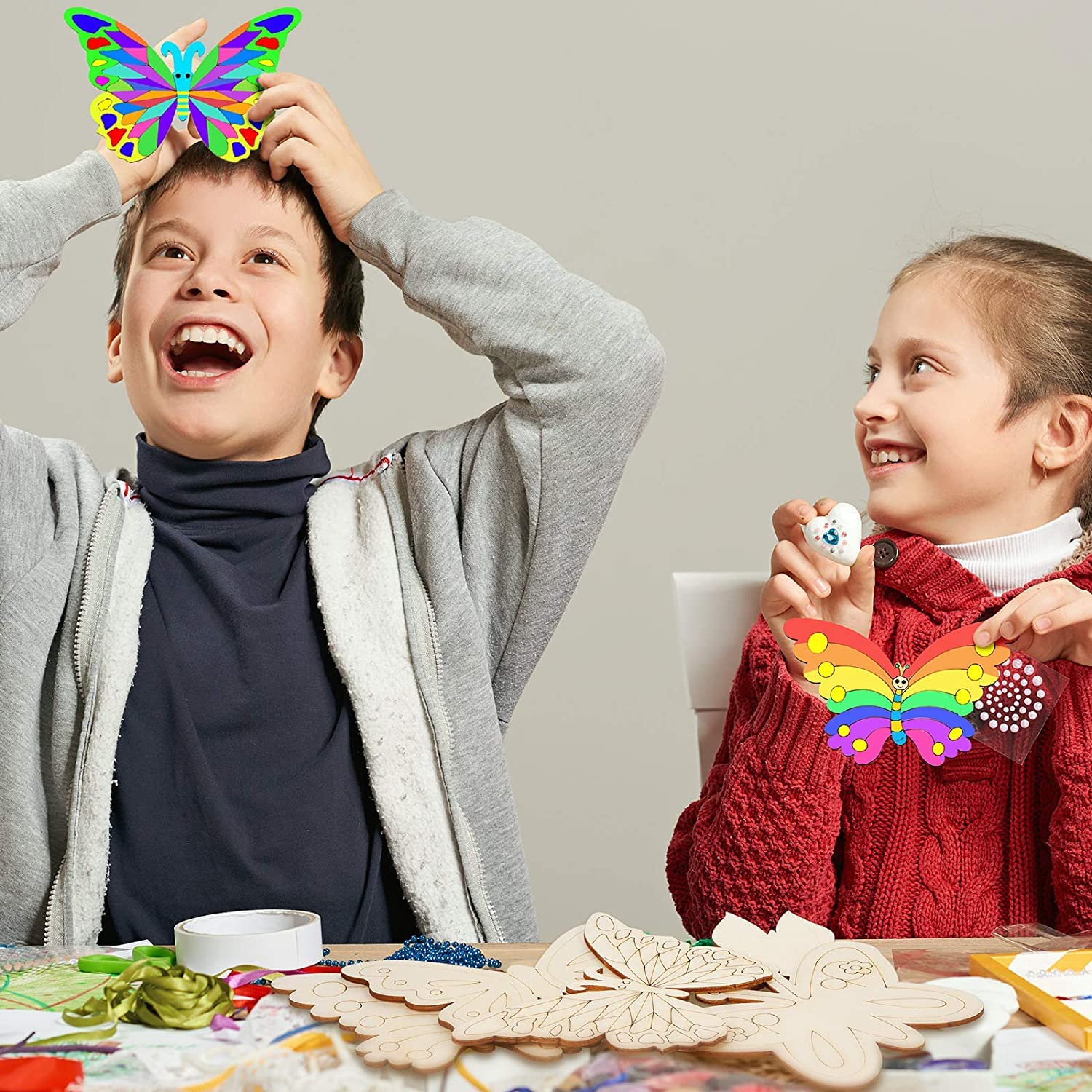 Two children playing with colorful butterfly decorations indoors.