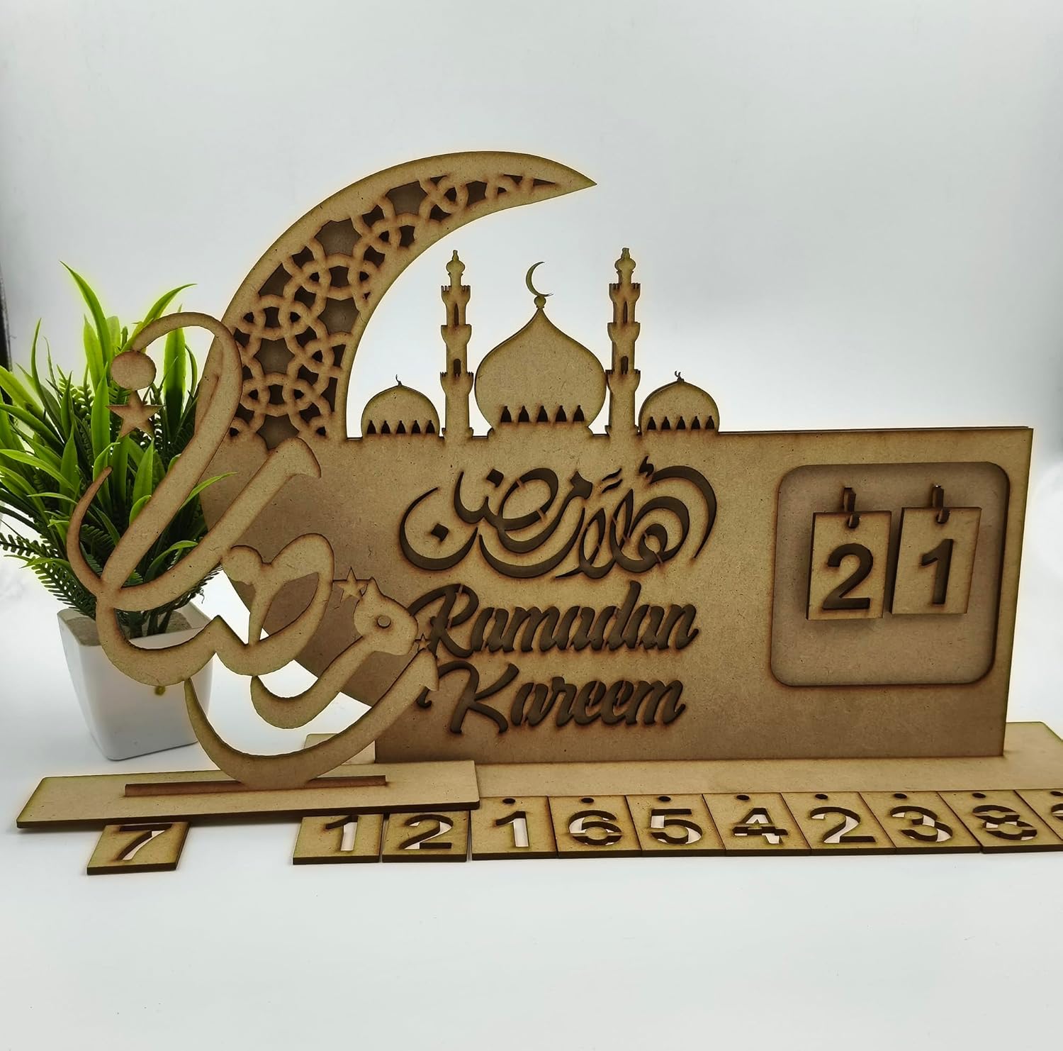 Wooden Ramadan Kareem decorative item with crescent moon, mosque silhouette, and calendar.