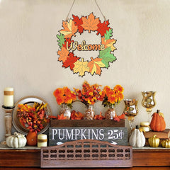 Decorative autumn wreath with 'Welcome' text, pumpkins, and floral arrangements on a table.