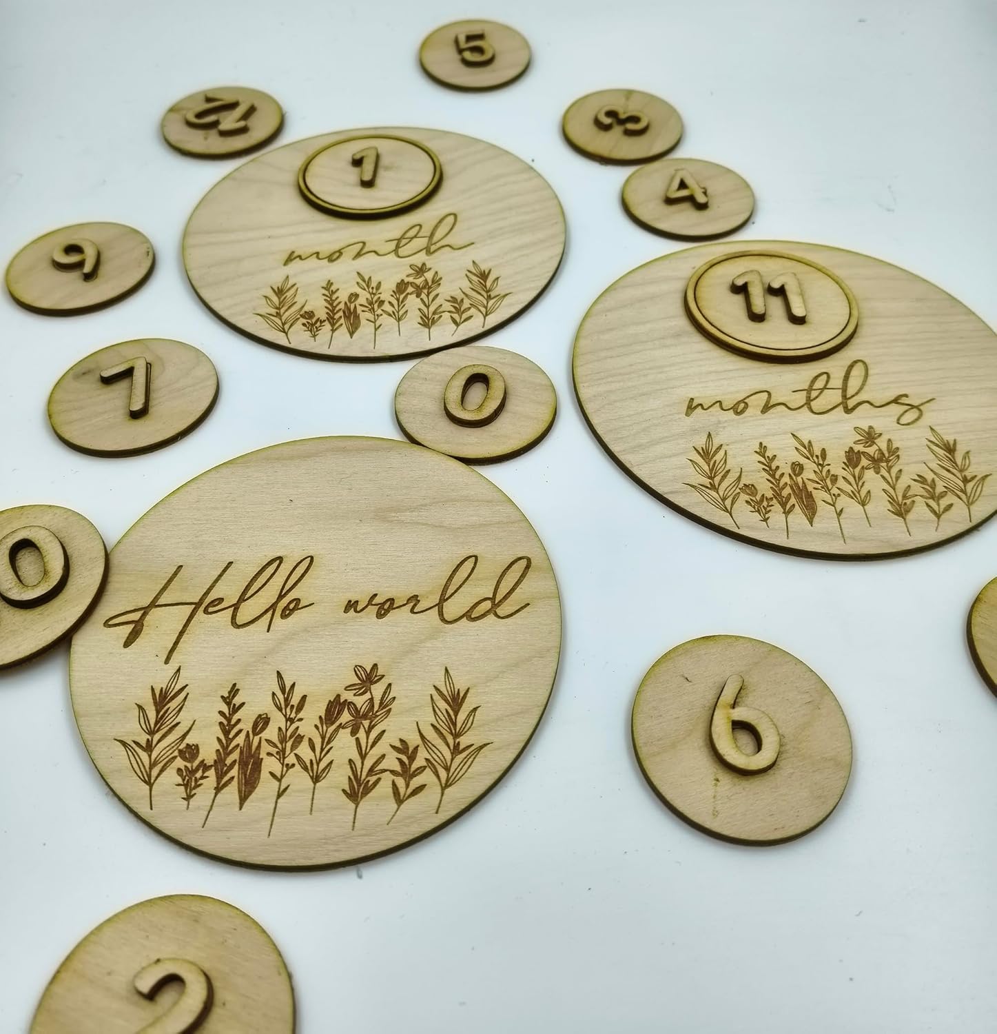 Wooden circular discs with engraved numbers and 'Hello world' text on a white background