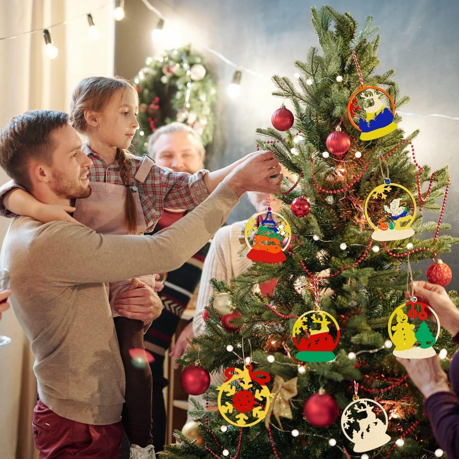 Family decorating a Christmas tree with ornaments in a cozy living room.