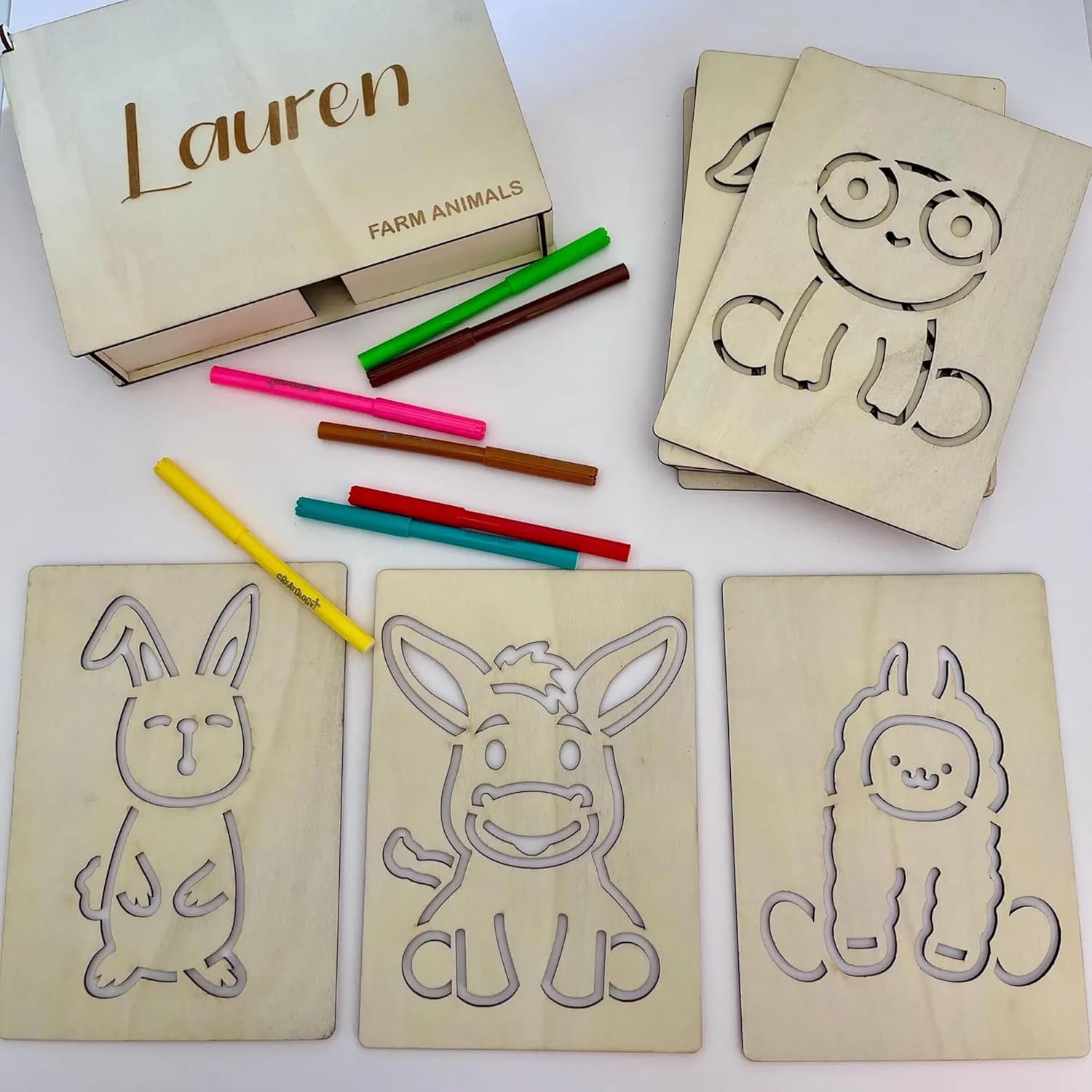 Wooden cards with farm animal outlines and colored pencils on a white background