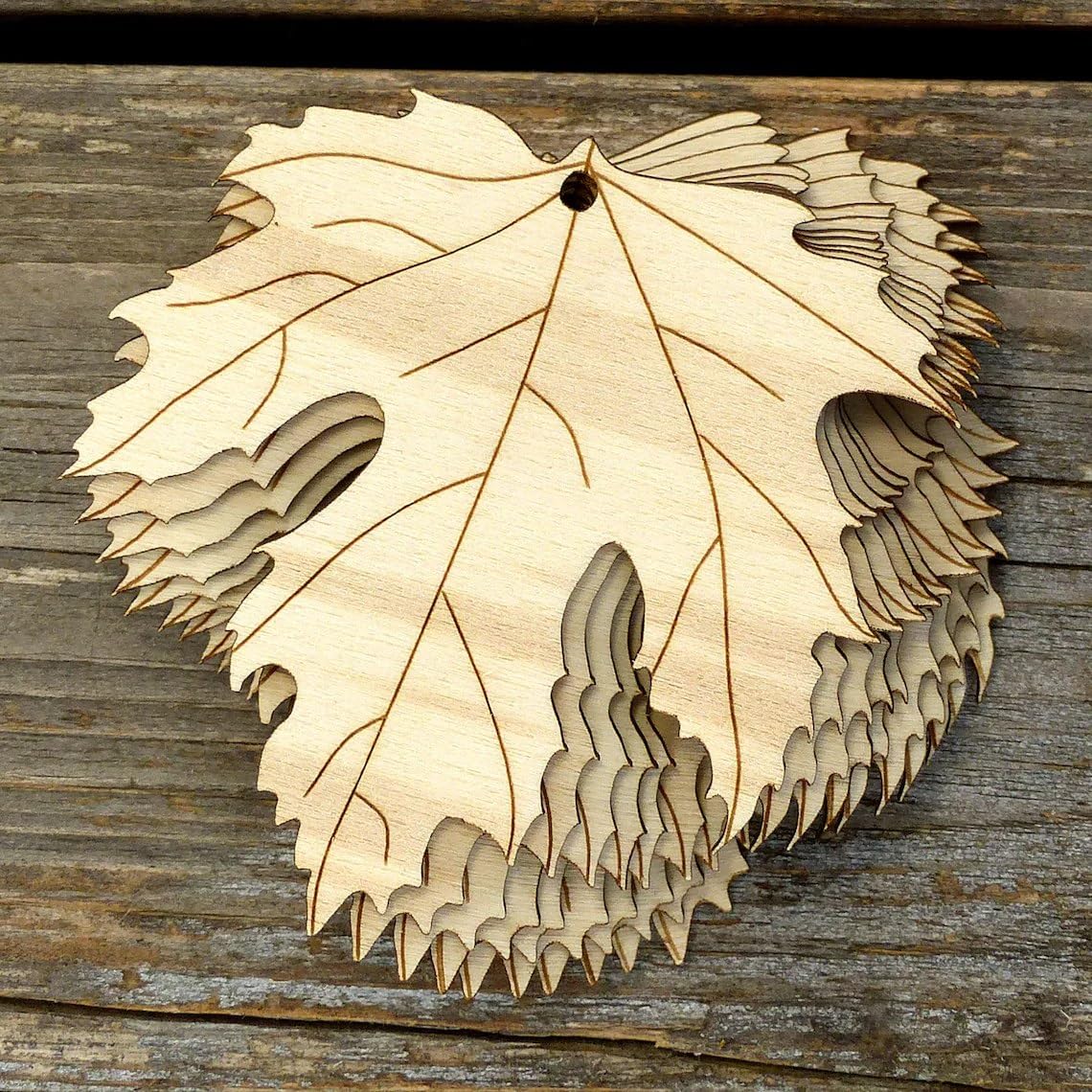 Wooden leaf-shaped cutout on a wooden surface