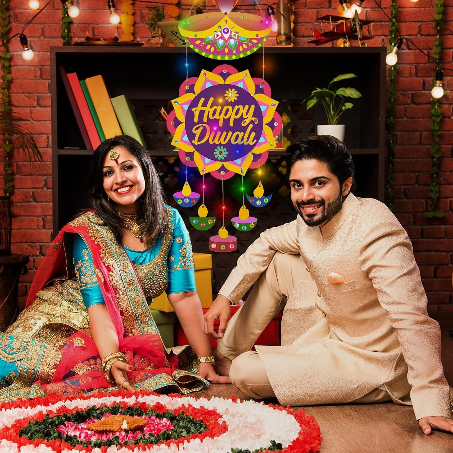 Couple in traditional attire celebrating Diwali with a decorated room and 'Happy Diwali' sign.