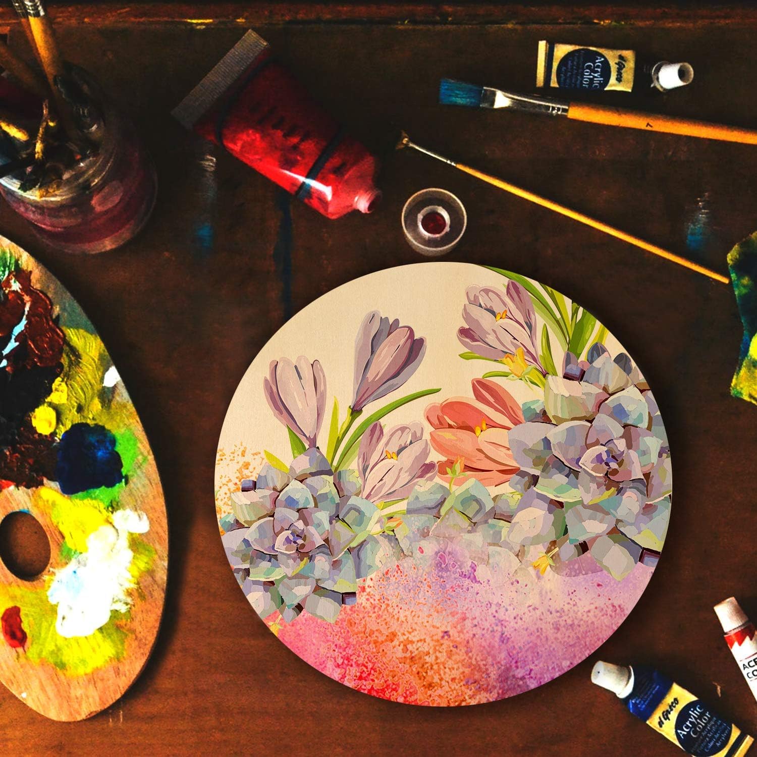 Artistic depiction of flowers on a round painting surface with paint palette and brushes on a wooden table.