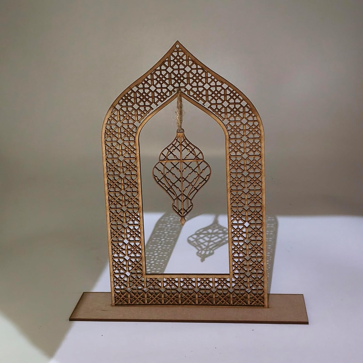 Decorative wooden arch with intricate cut-out patterns on a plain background
