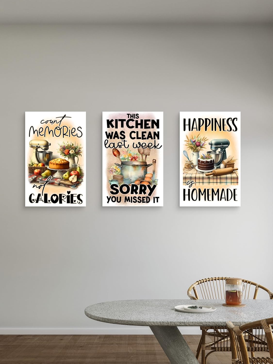 Three kitchen-themed wall posters on a wall above a dining table.