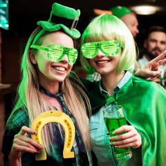 Two people celebrating with green-themed accessories and drinks in a festive setting.