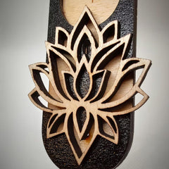 Wooden sandal with a detailed lotus flower design on a gray background