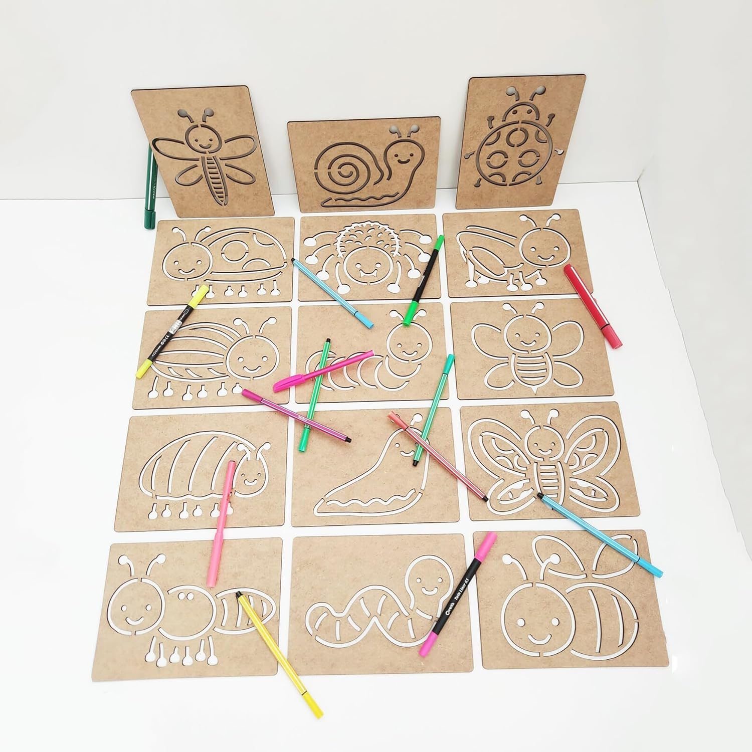 Set of cardboard templates with animal outlines and colored pencils on a white background
