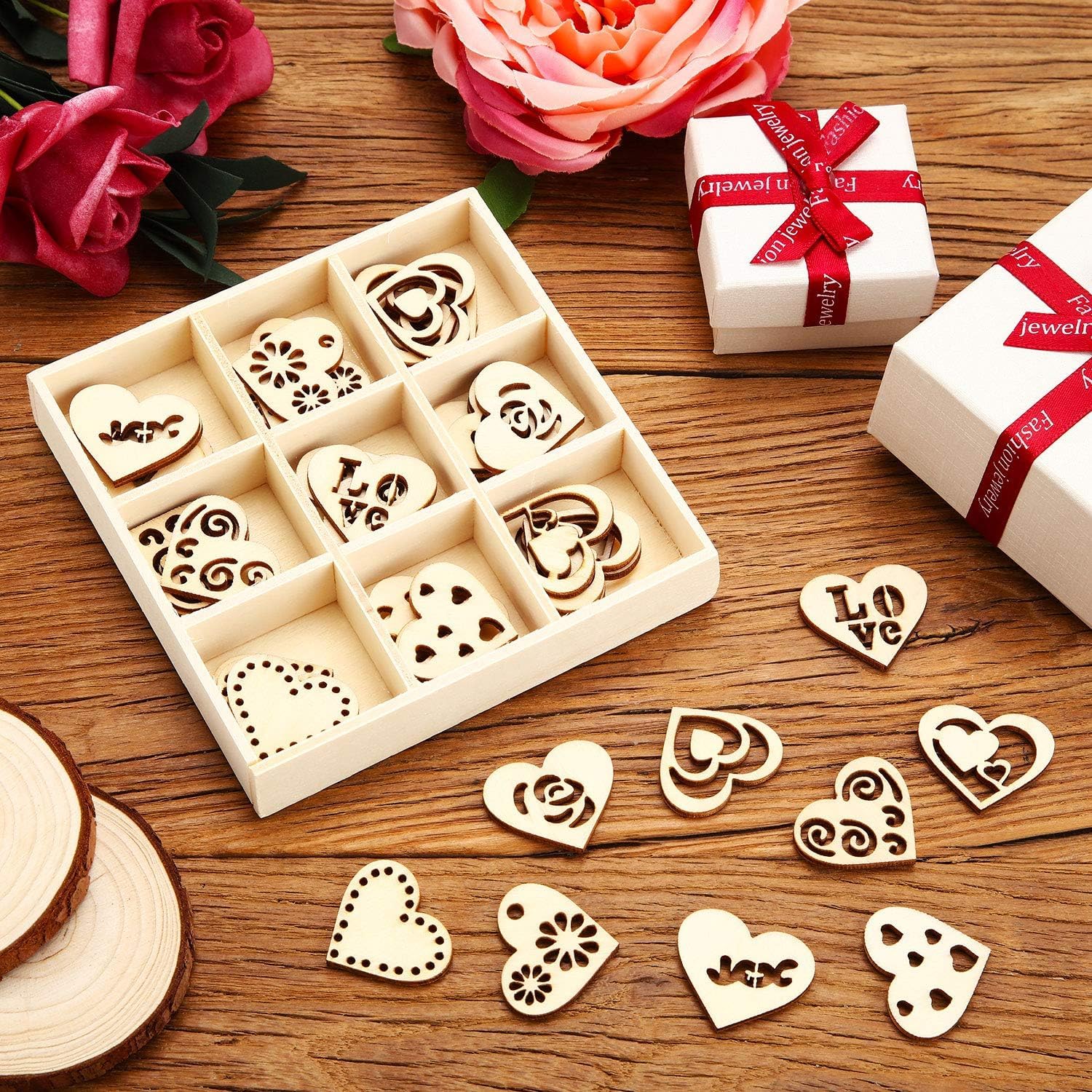 Wooden heart-shaped stamps in a box with decorative ribbons and flowers on a wooden surface