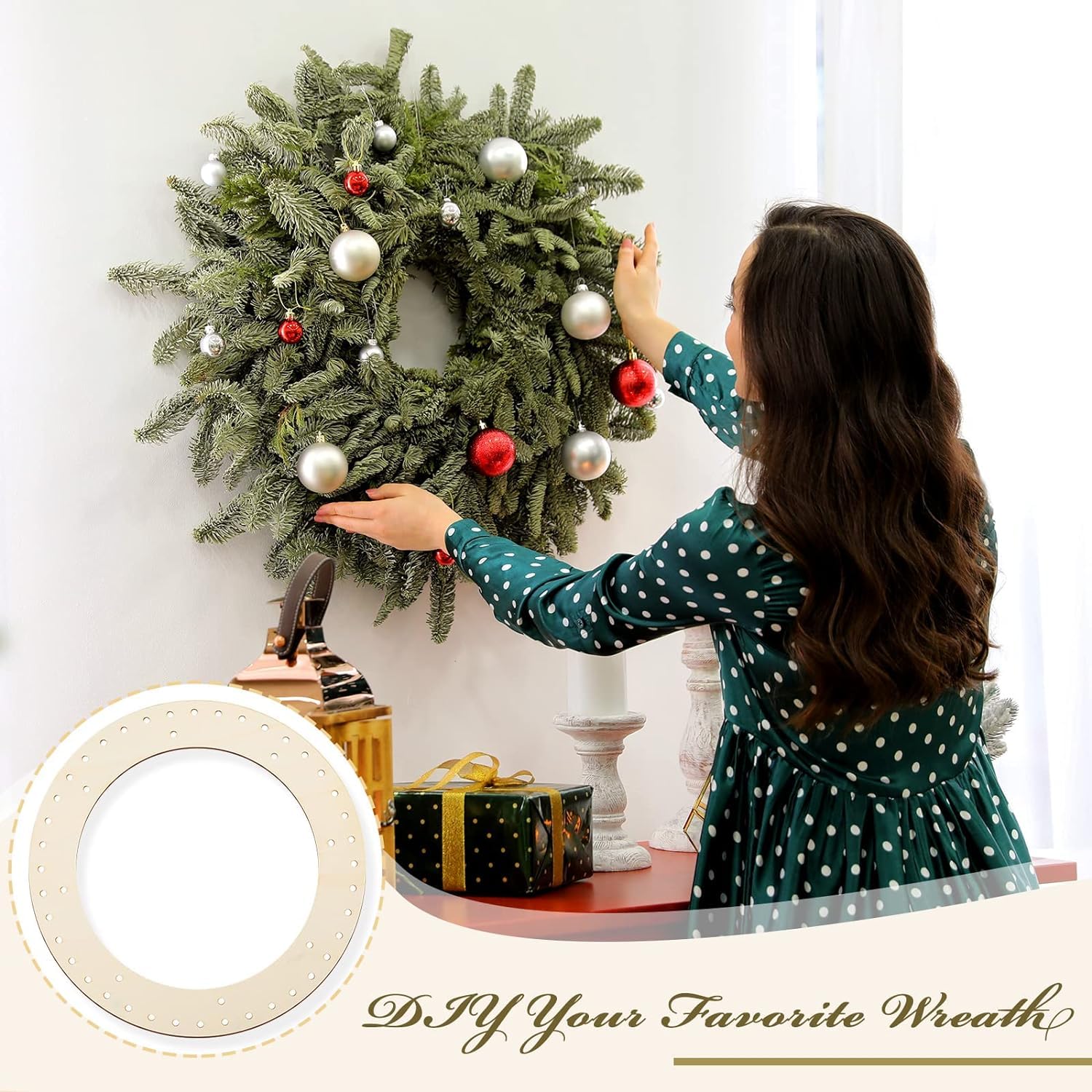 Woman decorating a Christmas wreath with ornaments on a white wall.