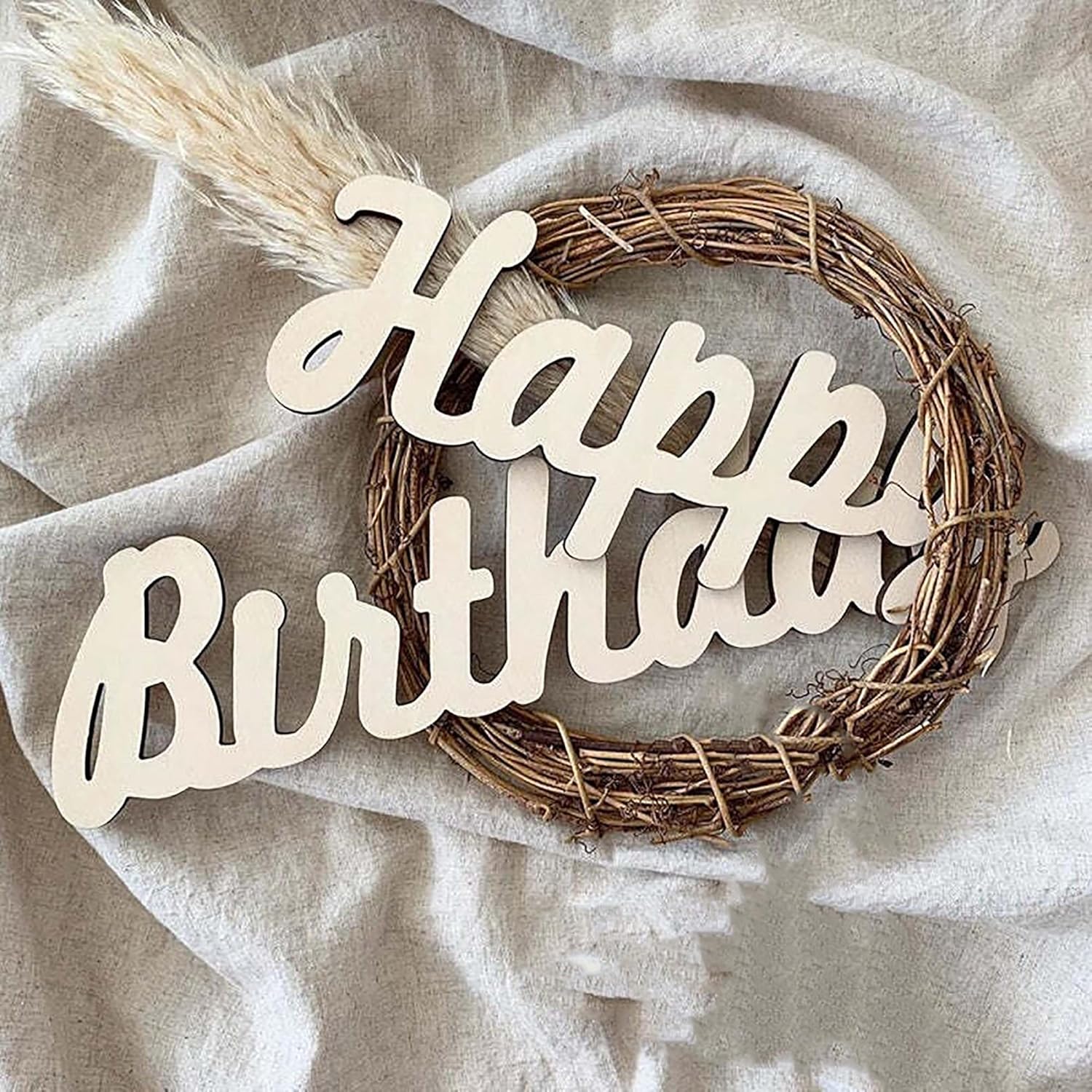 Wreath with 'Happy Birthday' text on a light fabric background
