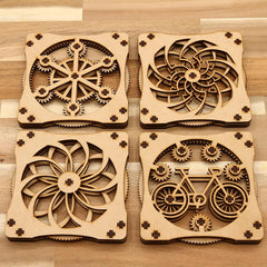 Four wooden coasters with intricate cut-out designs on a wooden surface