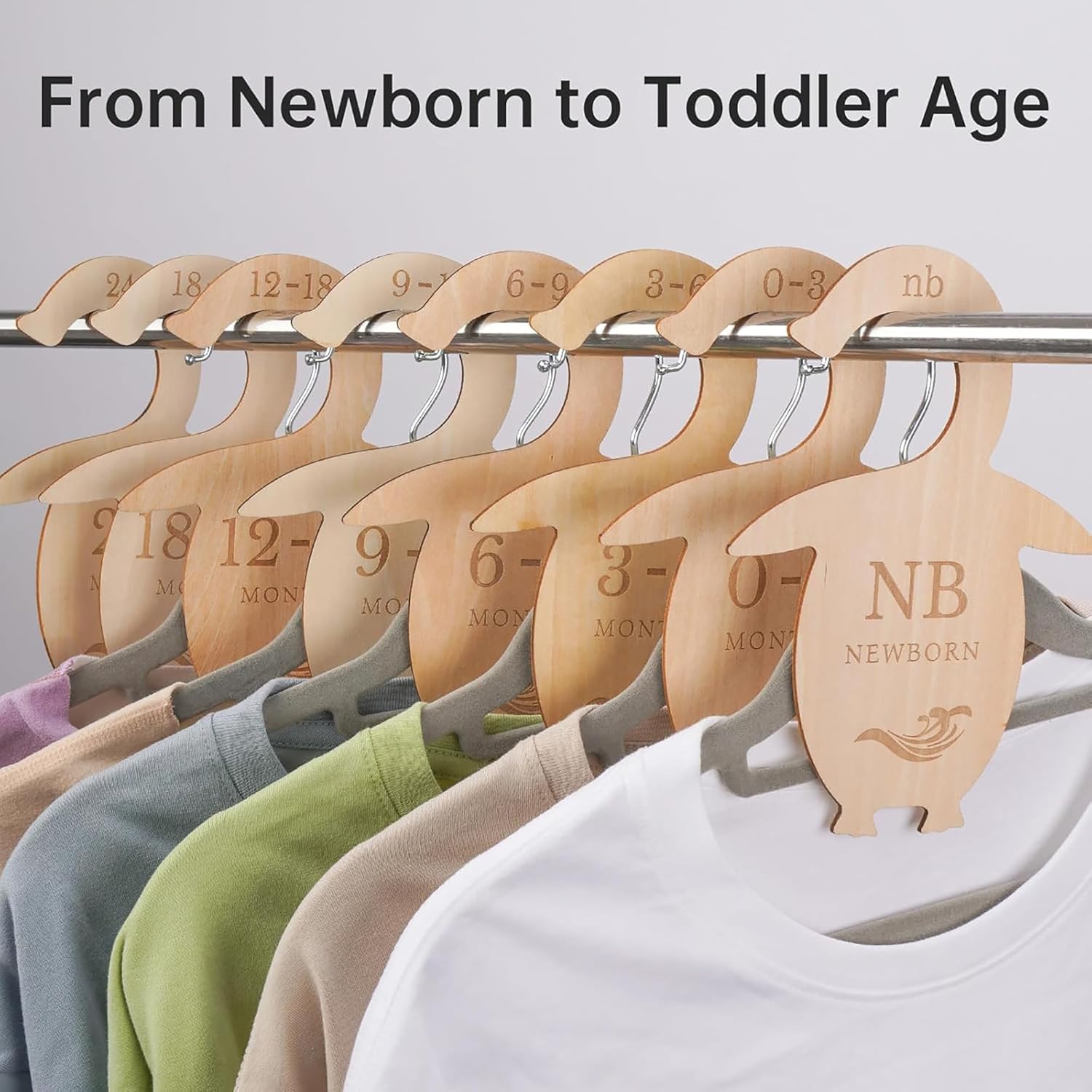 Set of wooden hangers with size markings from newborn to toddler age on a gray background.