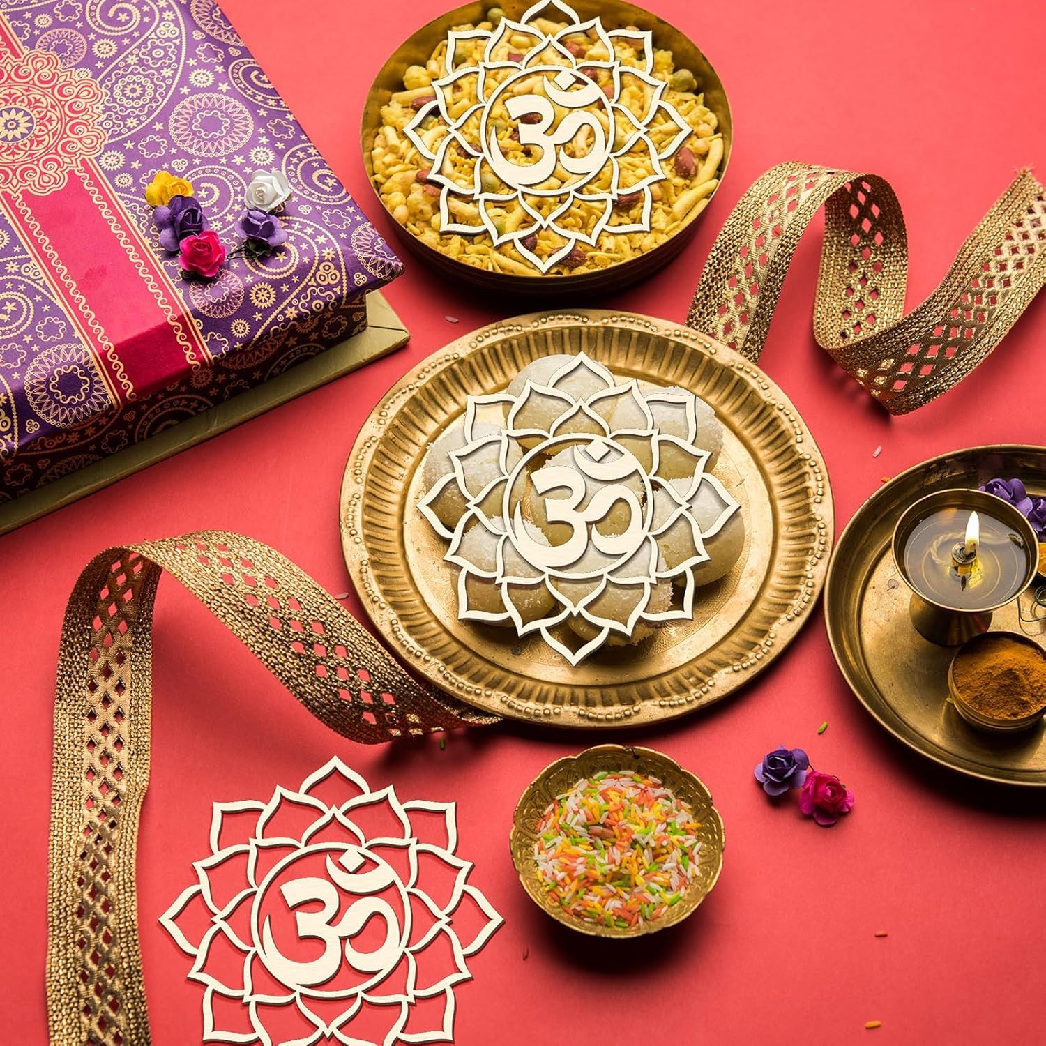 Decorative setup with gold plates, bowls, and a purple gift box on a red background.